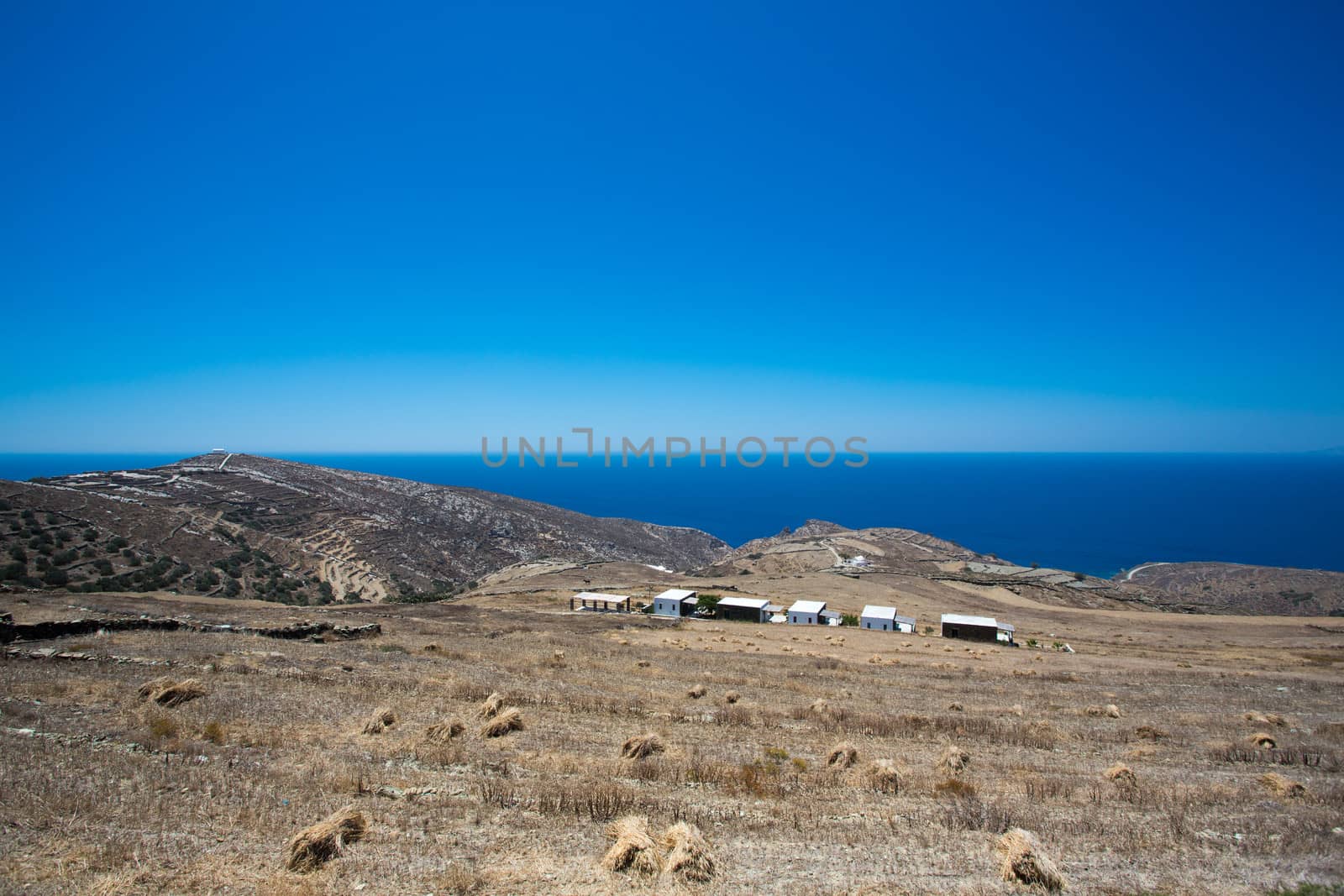Panoramic view of the seashore of Folangandros, in the distance  are some traditional greek houses and a view of the peaceful aegean sea, Greece, 2013.