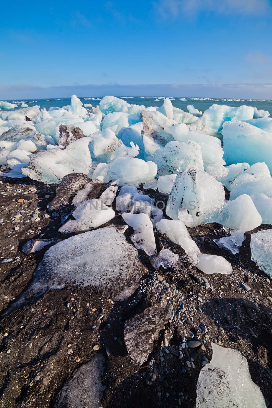 Ice blocks on a sand beach. by maxoliki