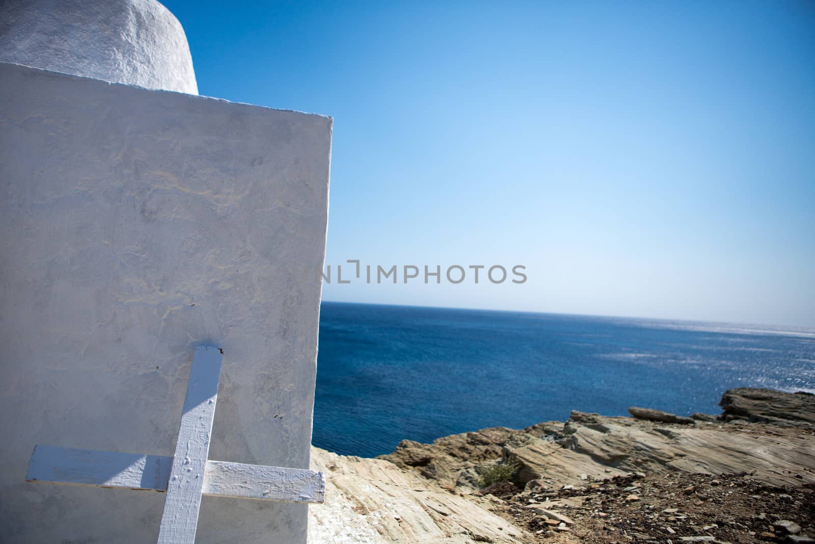 Close up from a simple white painted wooden cross at the  Gorgeous white orthodox  church of Panagia of Chora , Island of Folegandros , Aegean sea (Cyclades).These churches are scattered across the tiny island, often in incredibly remote and uninhabited areas of the island. Greece, 2013.