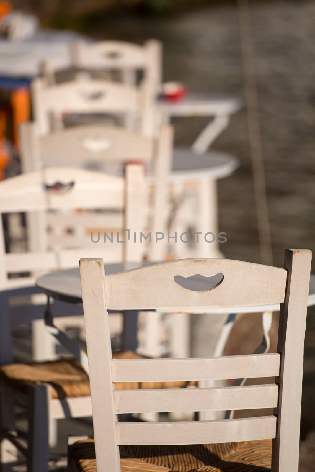Close-up from a white chair and white table. A traditional terrace of a restaurant in crete, Greece 2013.