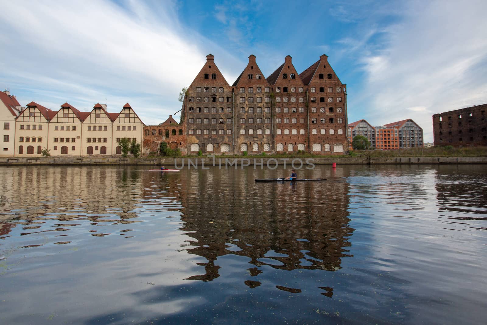 GDANSK, POLAND, SEPTEMBER 18: Unidentified people rowing on the Motlawa River in front of abandoned old industrial buildings, free city of Gdansk - 2013, Danzig, Poland