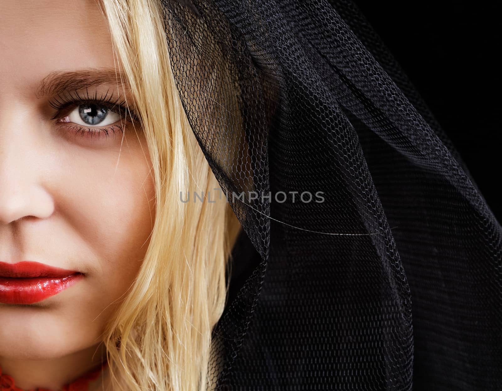 portrait of blue-eyed blonde young woman in a black veil
