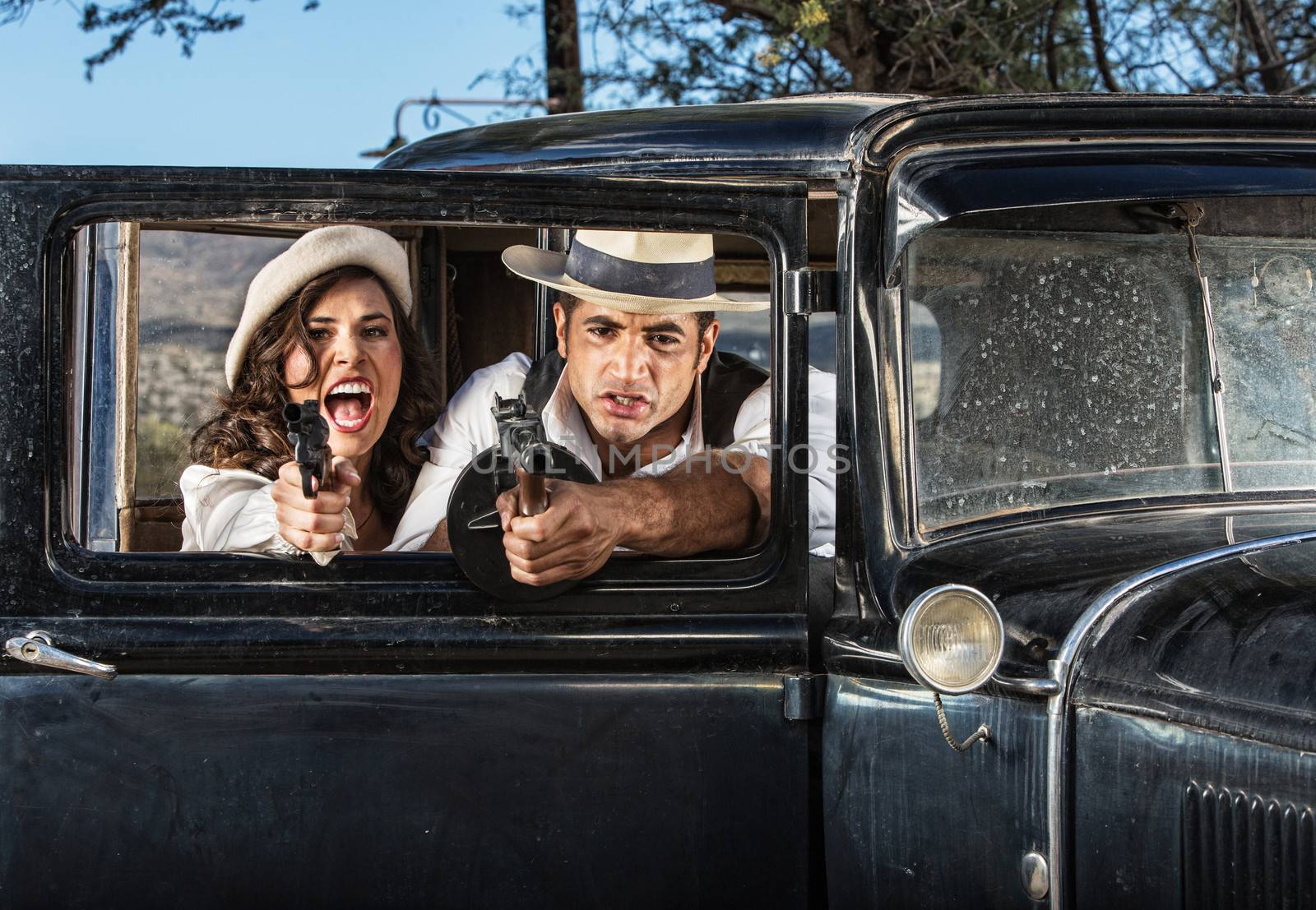 1920s vintage gangsters in shoot out behind car door