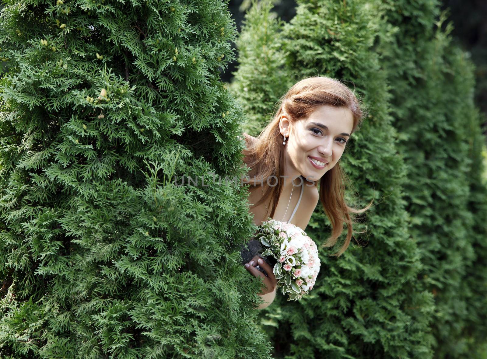 Beautiful bride between the trees in forest