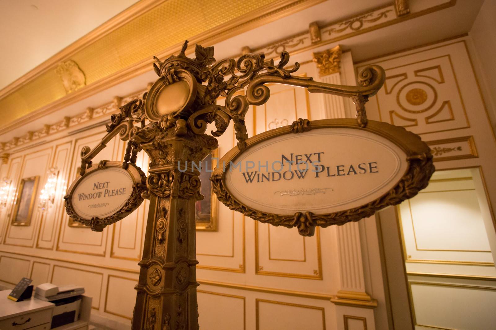 Hotel reception signs asking to go to the next window. Classical style.