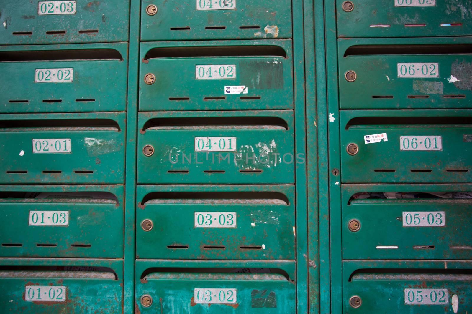 Pattern of old and unidentified green mailbox in an old residential building in Shanghai. Each number represents the floor and the flat number. China, 2013.