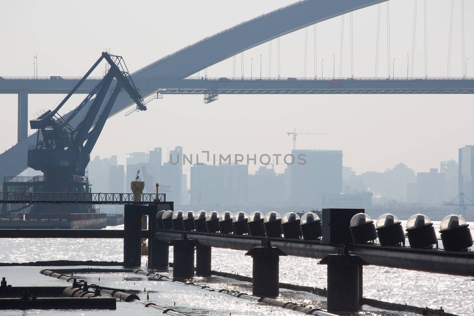 View of a massive bridge and the Shanghai harbor over the Huangpu River in Shanghai with buildings under construction in the background, China 2013