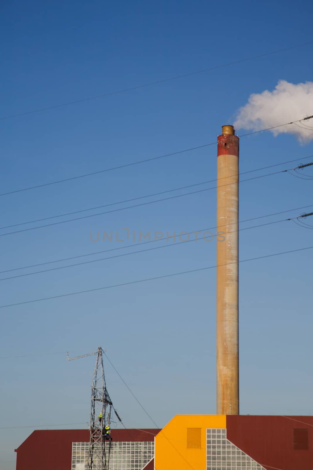 Incineration plant in Brussels, Belgium. Blue and clear sky with electrical wires.