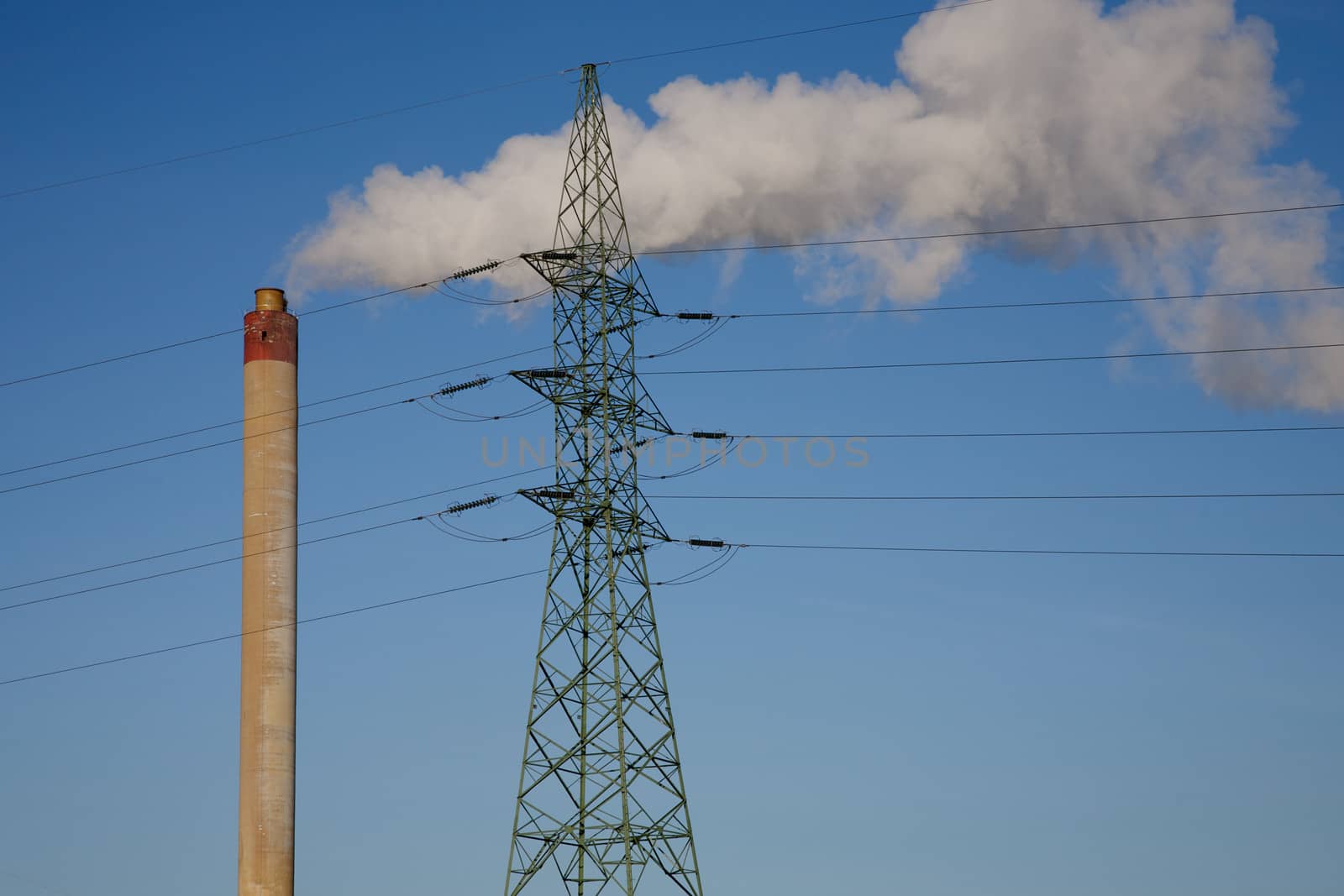 Incineration plant in Brussels, Belgium. Blue and clear sky with electrical wires.