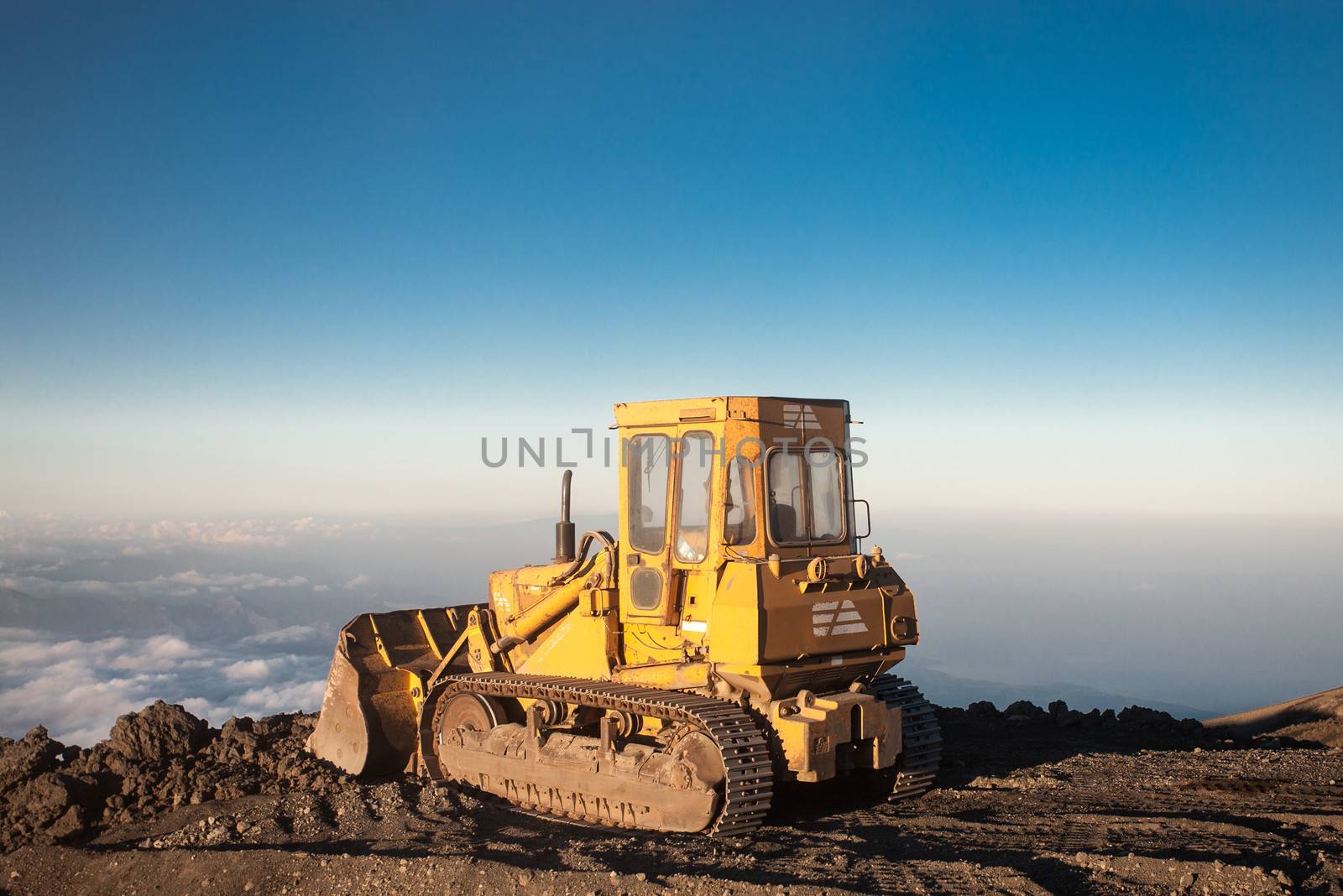 Yellow tractor at the top of the Etna mountain with view on the  by watchtheworld