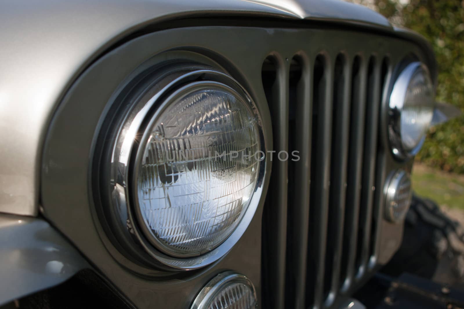 Front end, headlights and grille on a vintage four-wheel drive vehicle.