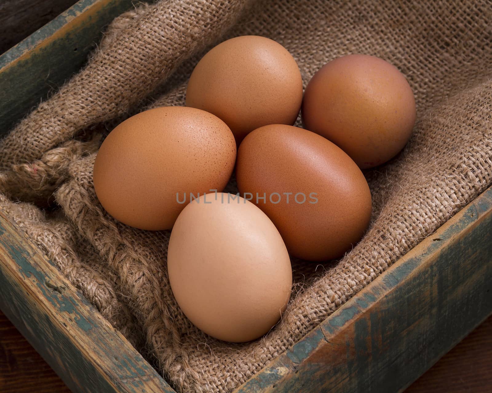 An old wooden box with some eggs on a sackcloth