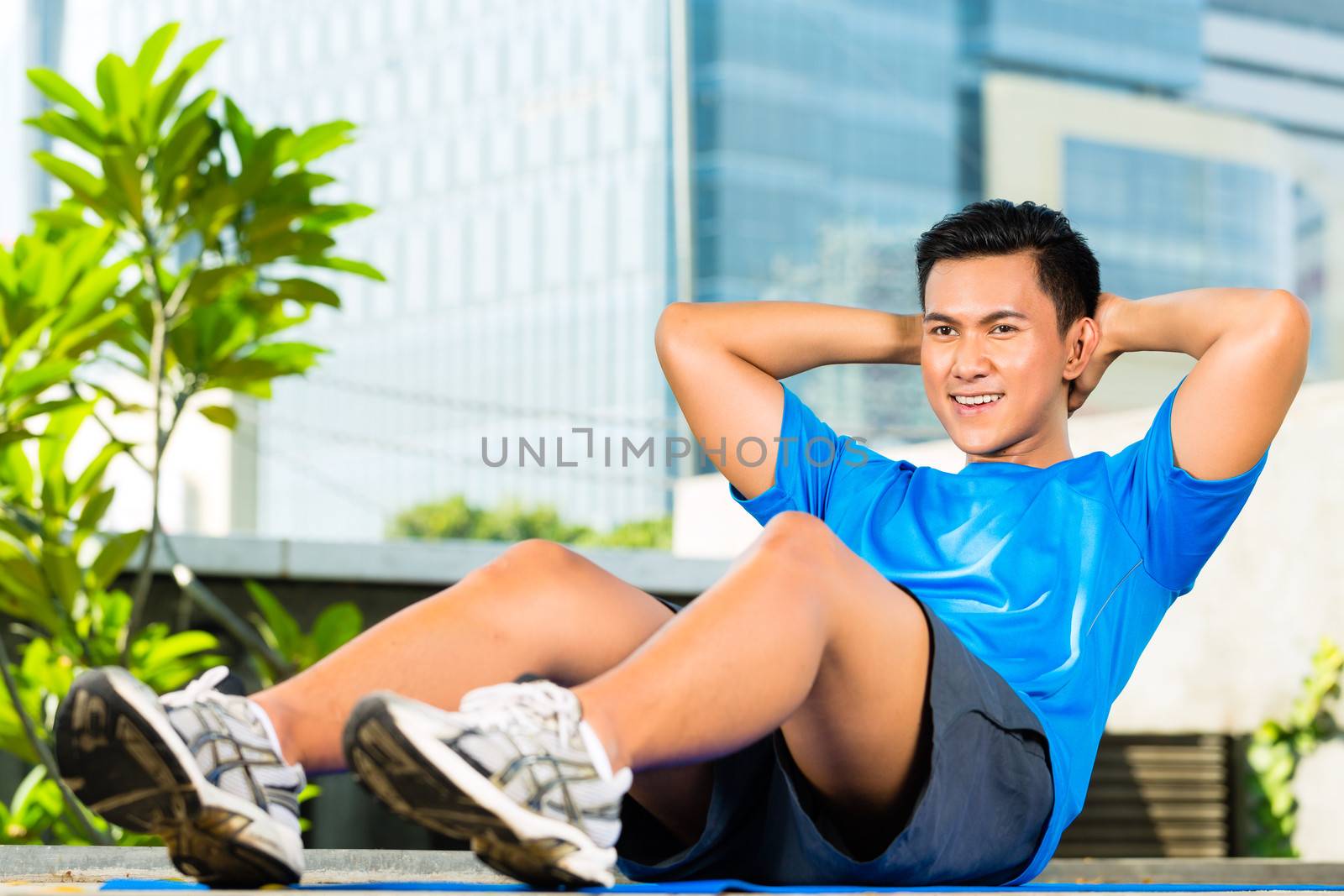 Urban sports - fitness in Asian or Indonesian city by Kzenon