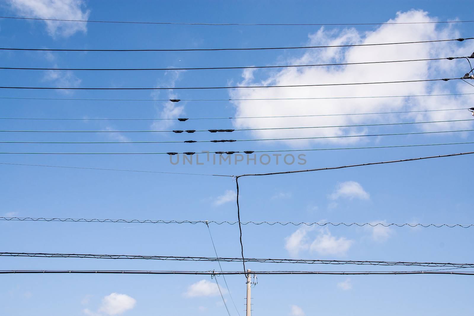 Power lines from poles on sky background
