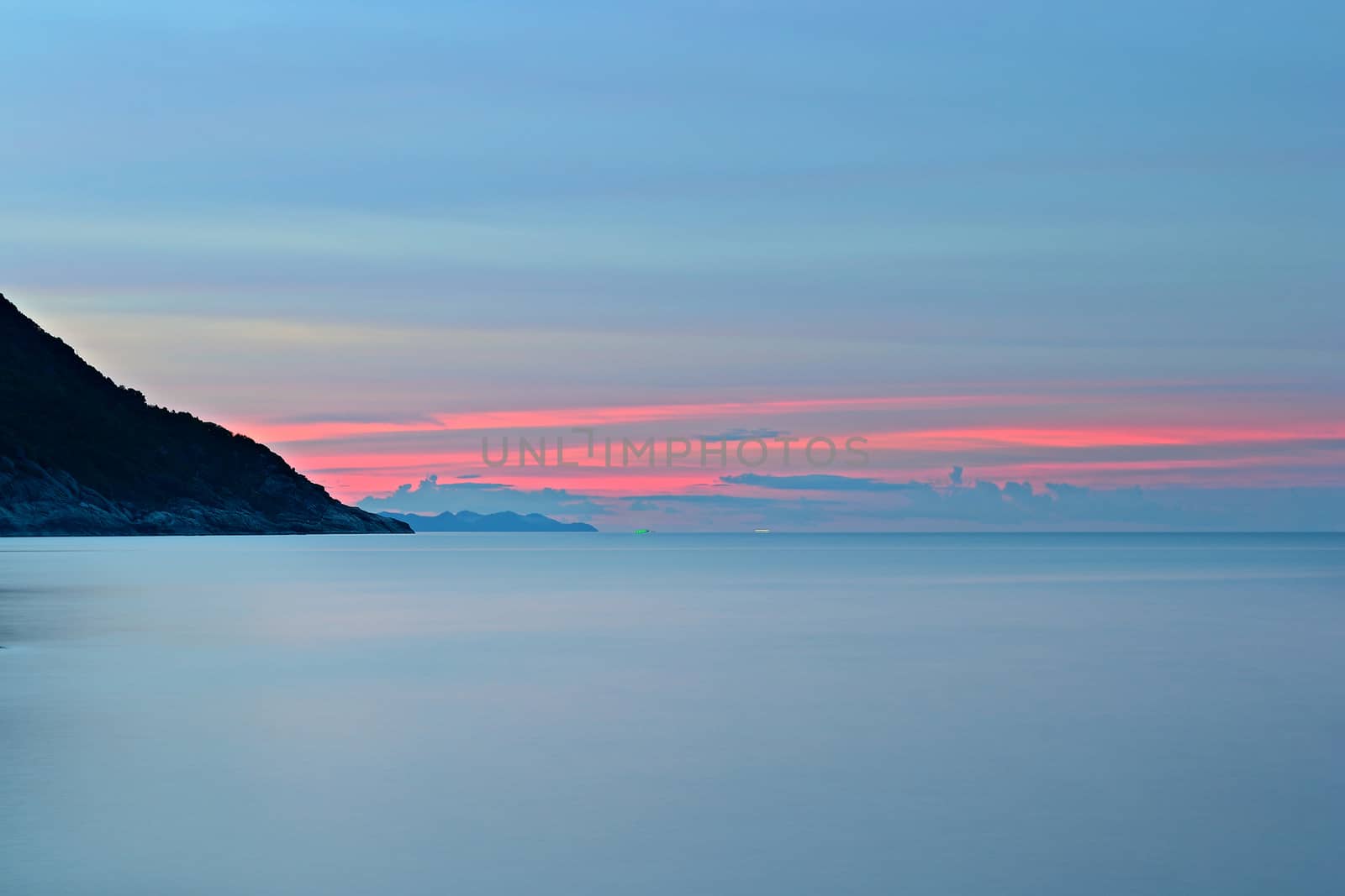 Vibrant colored sunset and blurred motion seascape at Ao Haad Khaud, Koh Phangan, Southern Thailand.