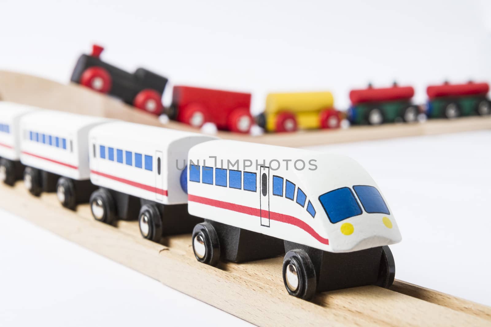 two wooden toy trains on railway isolated on white background