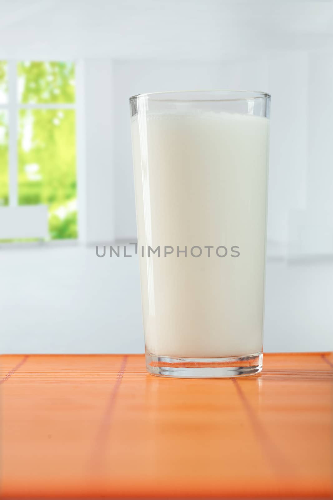 glass of milk on table by mihalec