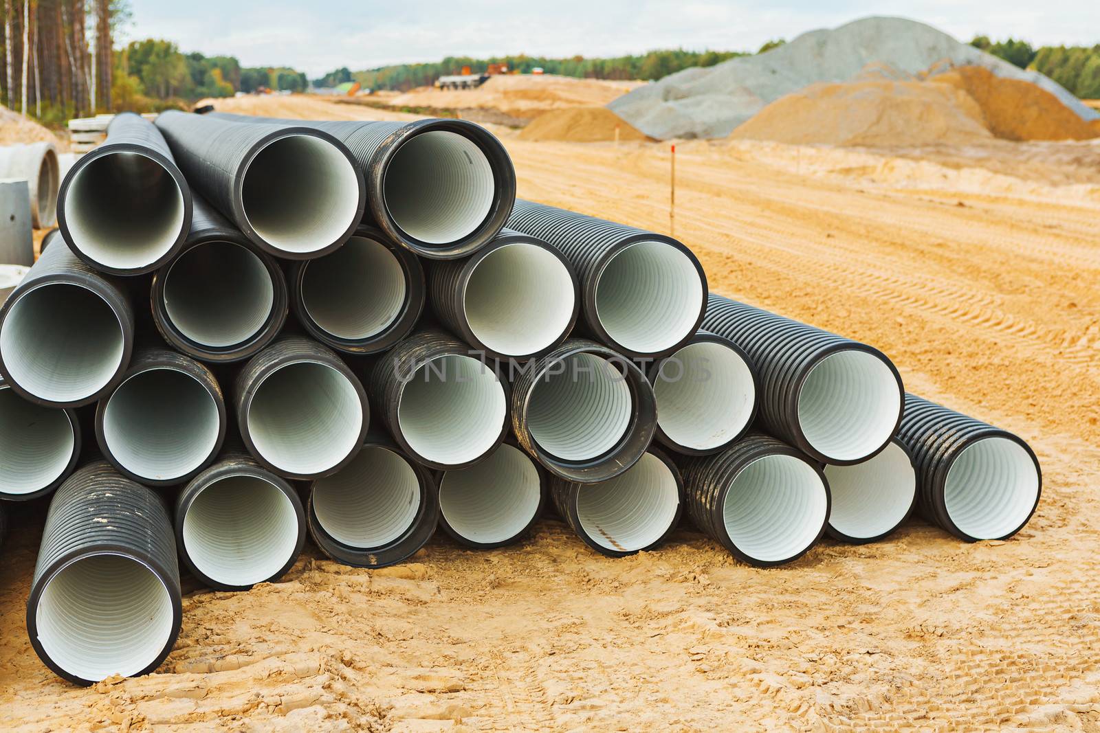pile of big pipes on construction site by mihalec