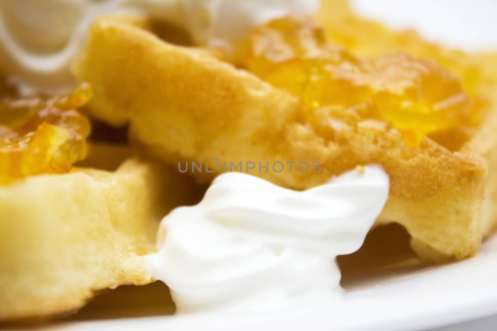 Toasted waffles with orange jam and cream on top.