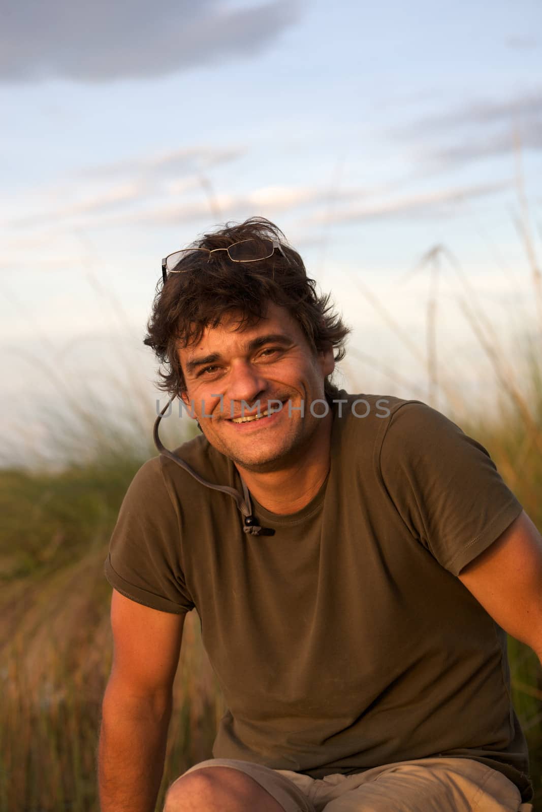 Portrait of an young man sitting on a wooden bench in the Okavango Delta in Botswana