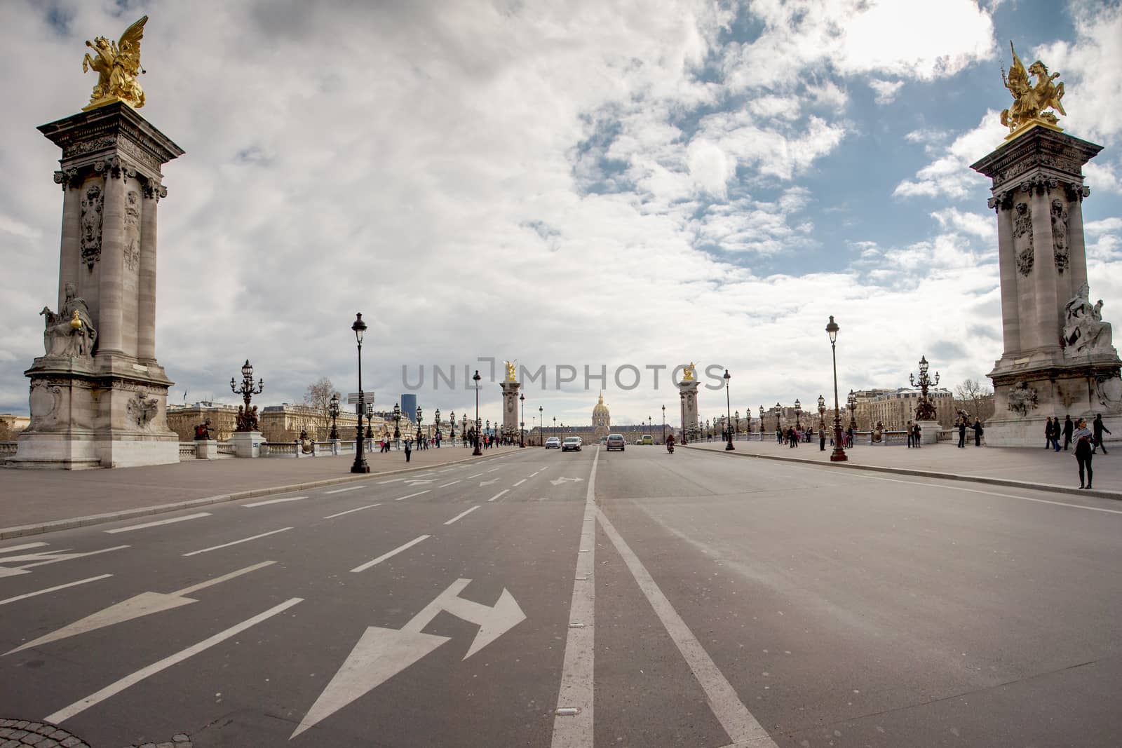 PARIS, FRANCE, MARCH 27: Empty street and Alexandre the third bridge with a view on the Invalides in Paris. A few unrecognizable people in the background.