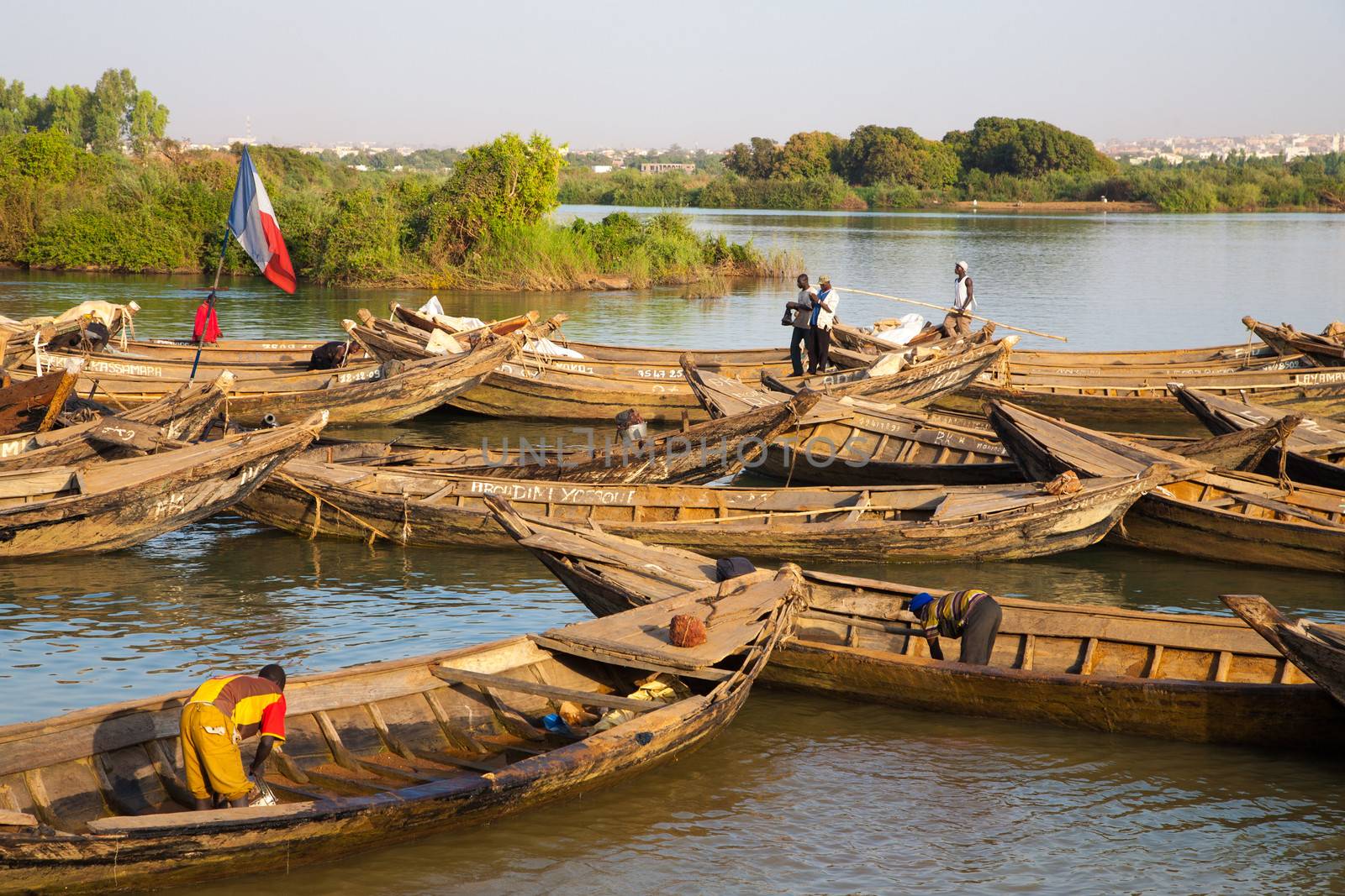 BAMAKO, MALI, JANUARY 7: Unidentified fisher men working in their boat on the Niger River in Bamako with the countryside in the background. Mali 2011