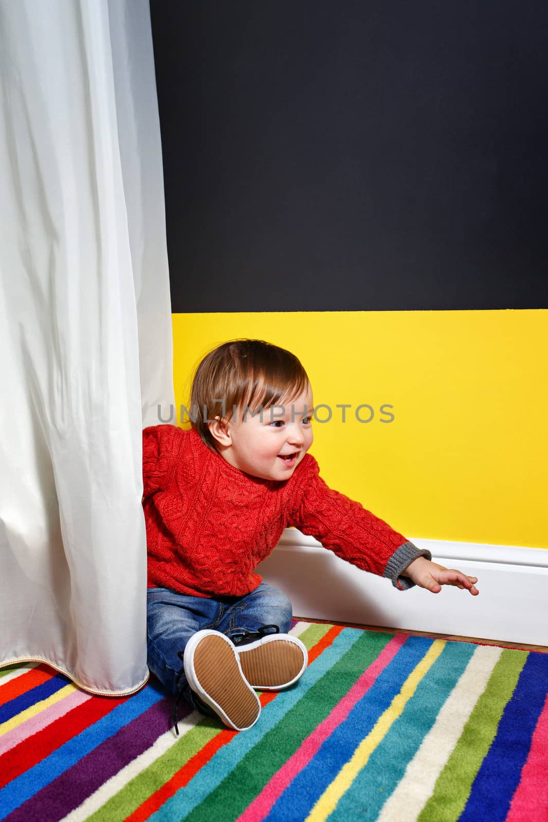 Cute little boy sitting on the floor in the living room