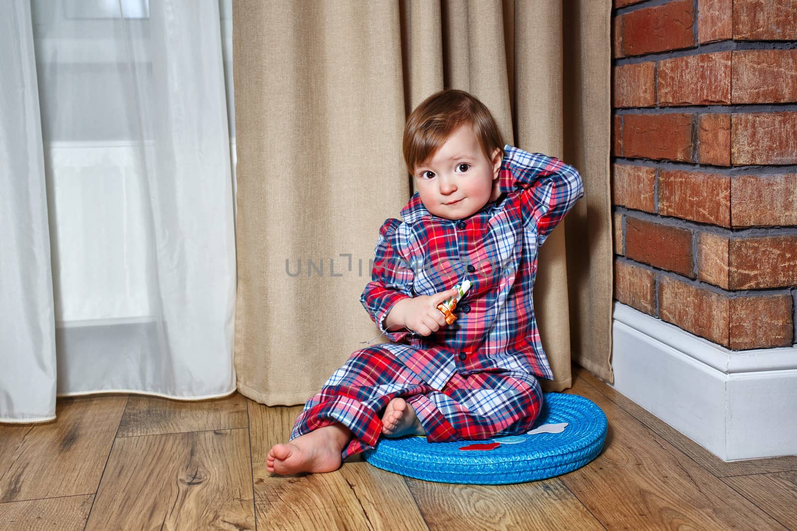 Cute little boy sitting on the floor in the living room