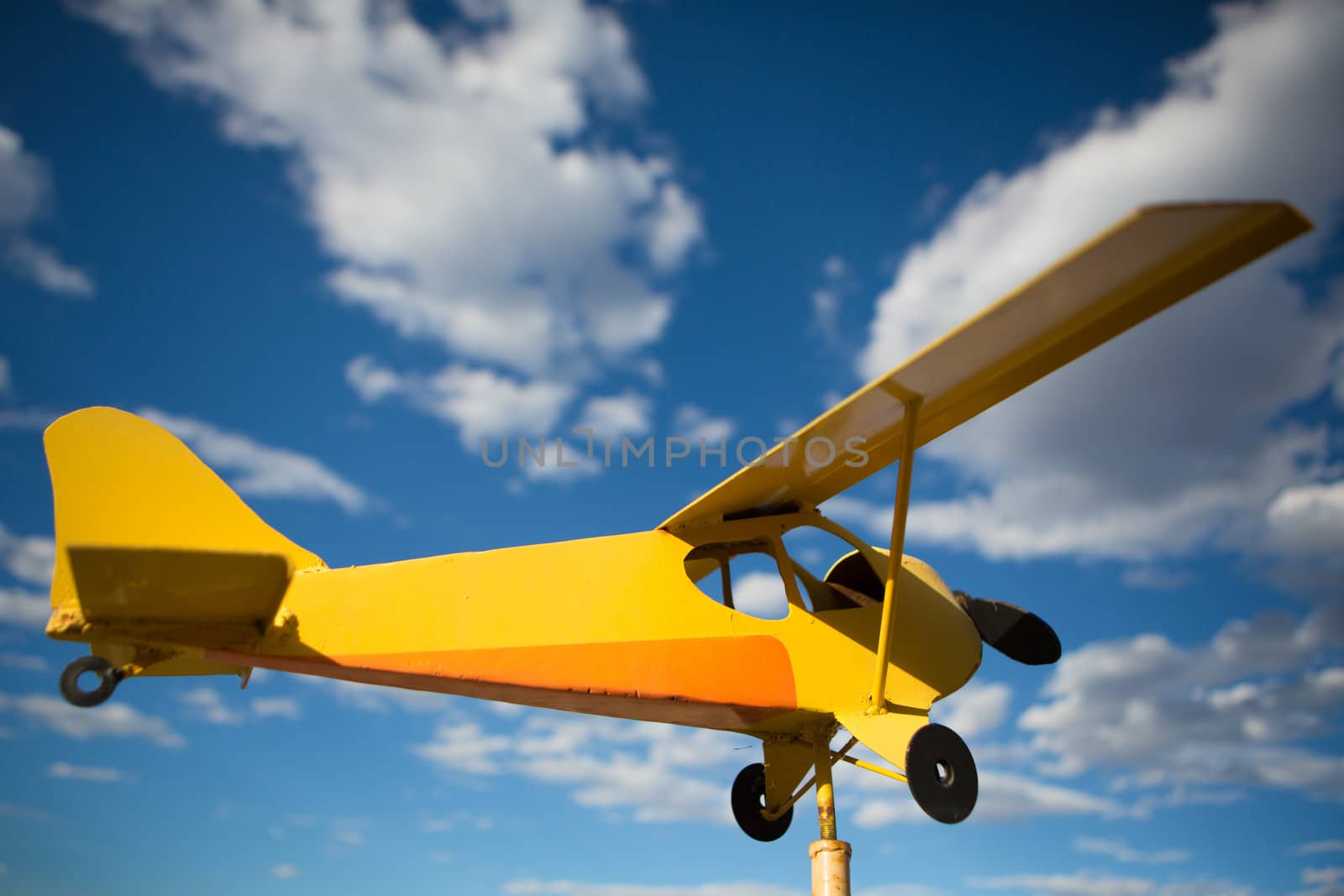 Yellow old airplane against sunny blue sky