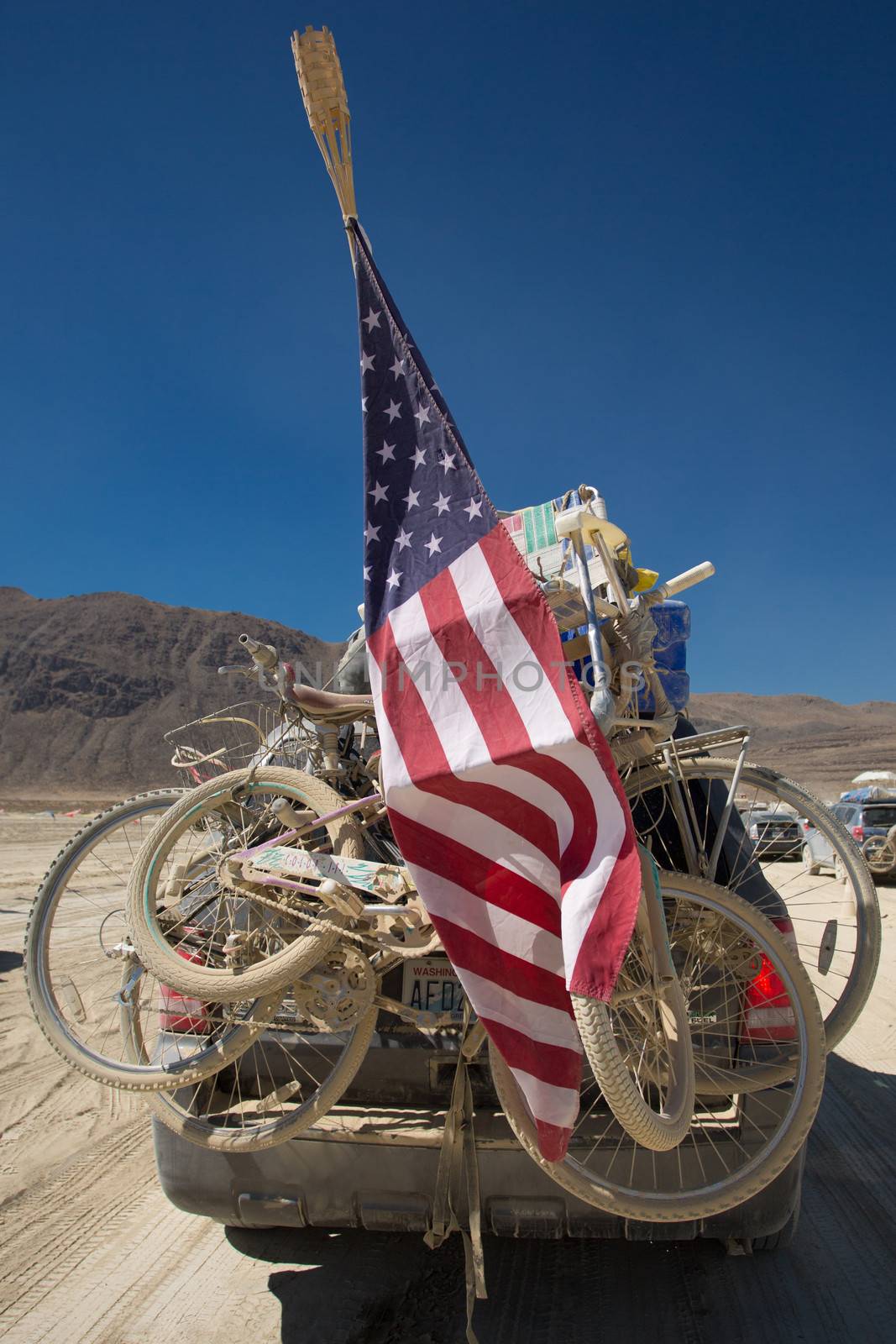 Mountain bikes on a car rack taken at the exit of the Burning Man festival in 2012 with US flags