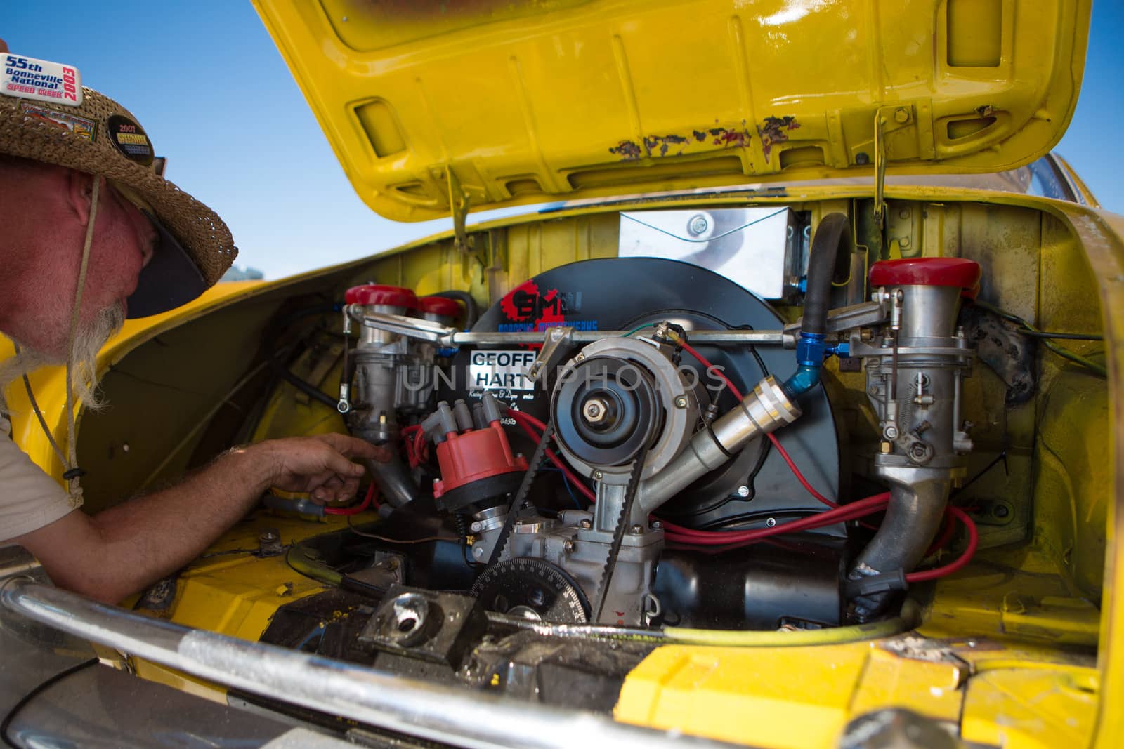 SALT LAKE, UT - SEPTEMBER 8: An unidentified man showing the engine parts of his speed yellow car during the World of Speed at Bonneville Salt Flats Recreation Area Utah USA.