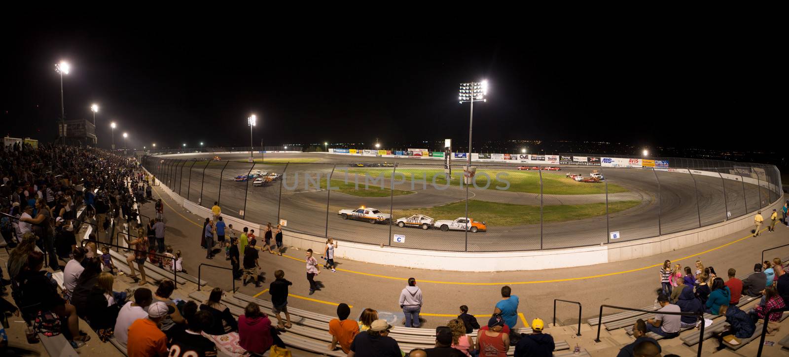 SALT LAKE CITY, NV, SEPTEMBER 9: Unidentified people watchting a stock car competition at night in a race track statium, Salt Lake City, Utah. The actual race is based on three car team, called the small train. September 9, 2013.