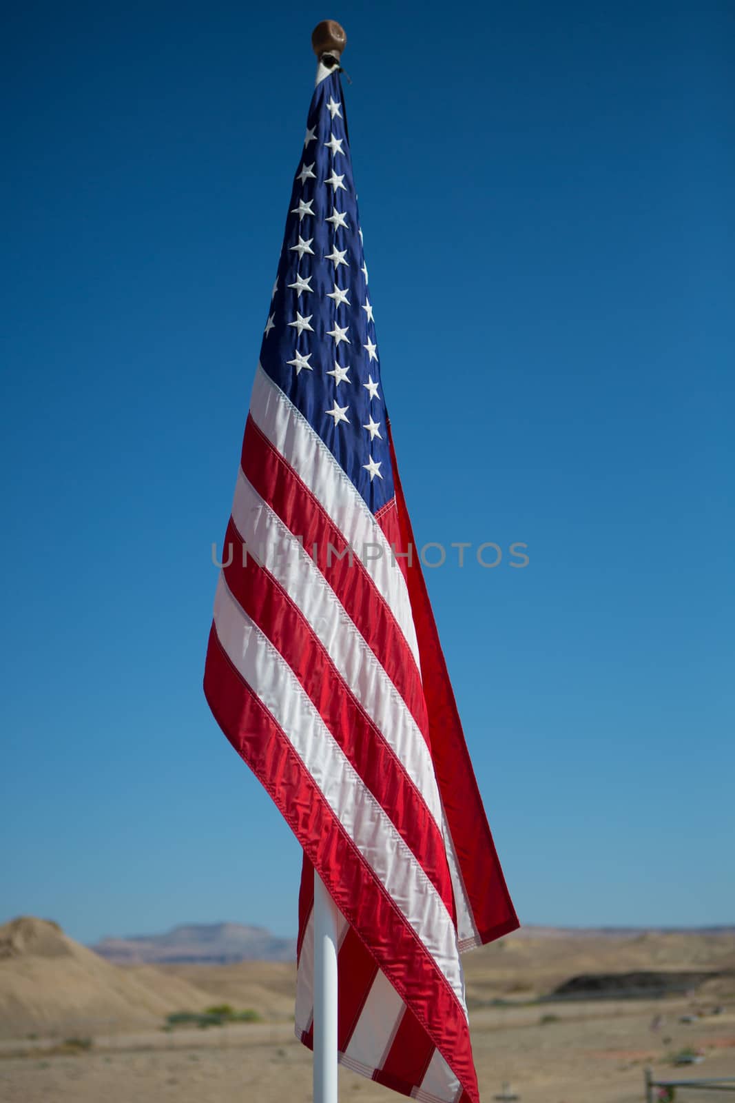 Flag on Flag Pole with blue sky and the desert of Utah in the background