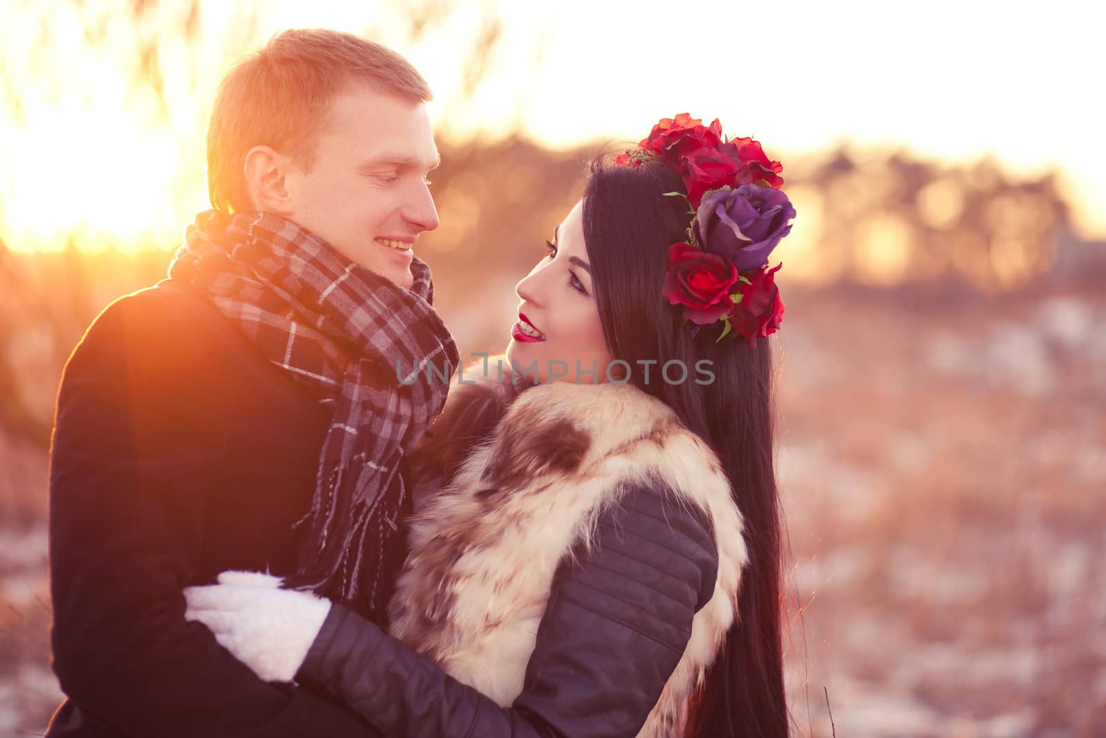 Cheerfull young lovers are smiling and hugging in sunlight