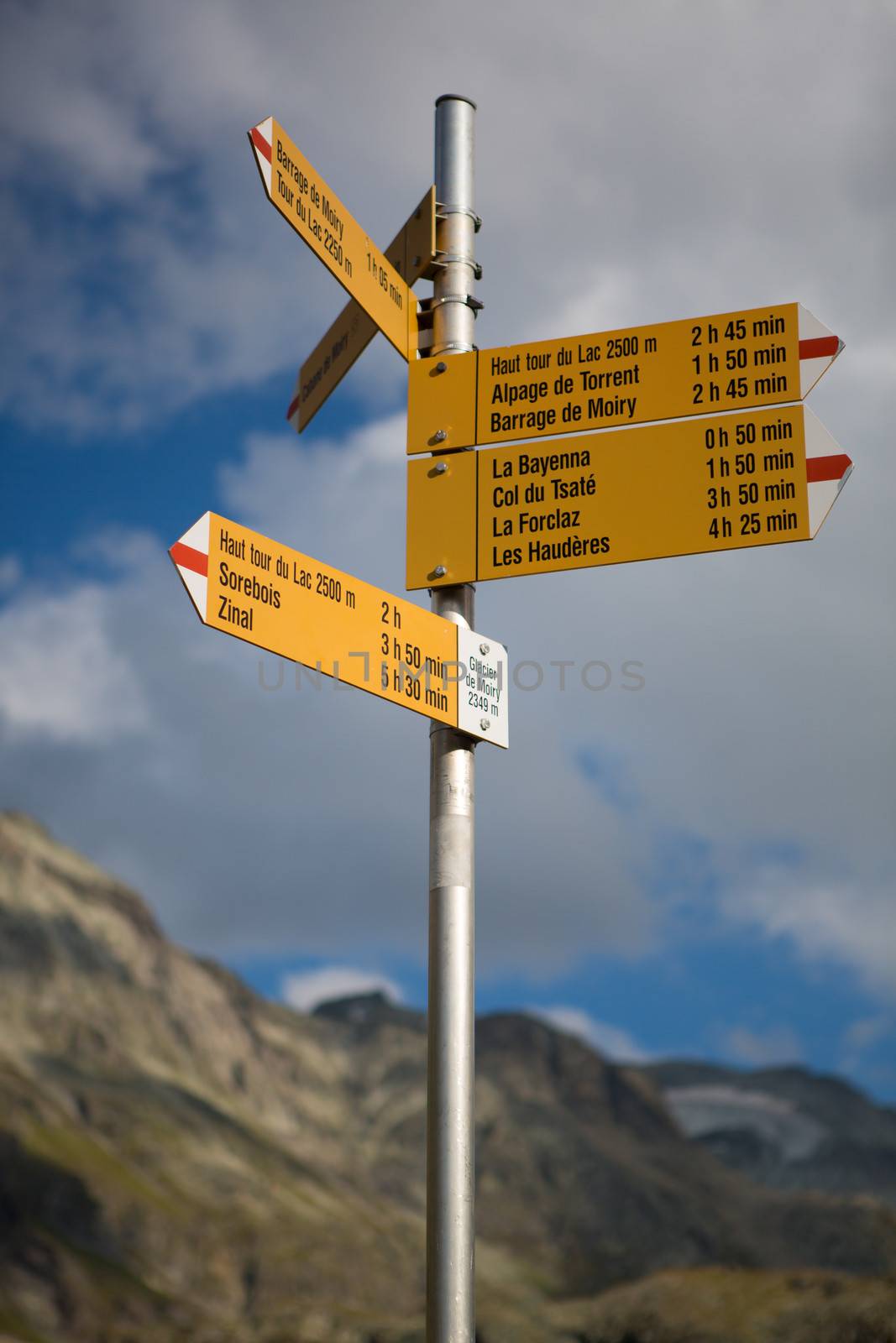 Road sign in the mountains of the canton of Valais, various signs with directions and distances between famous landmarks in Switserland