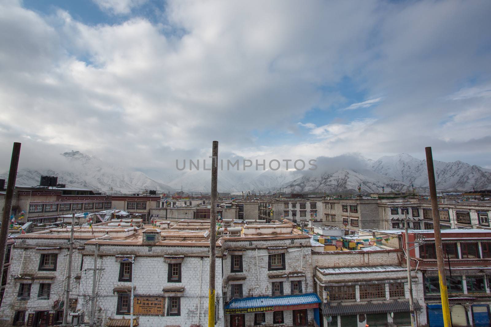 Rooftops in Lhasa and the snowy moutains early in the in the background. Tibet 2013.