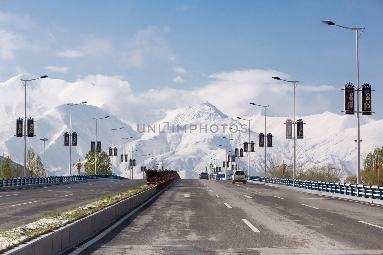 Leaving Lhasa on an empty Friendship Highway with a stunning view of the Himalayan mountain chain in the background. Tibet, China 2013.