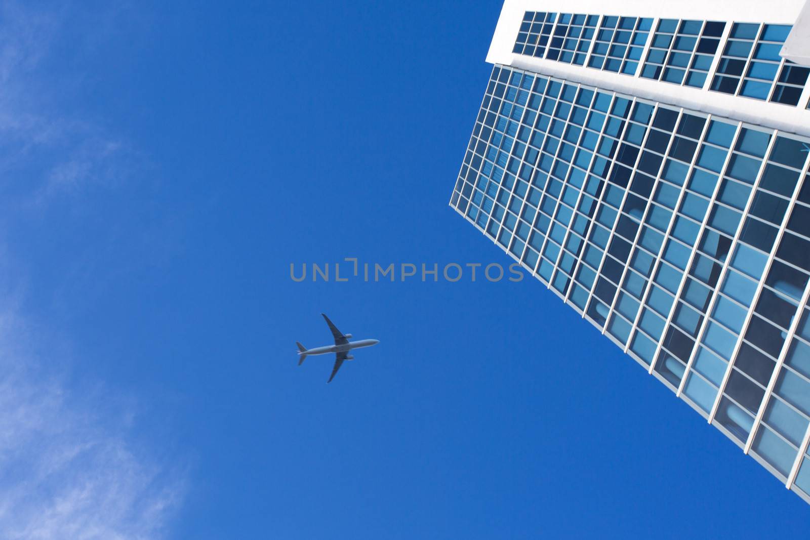 Airplane flying above a skyscraper in the sky of Miami