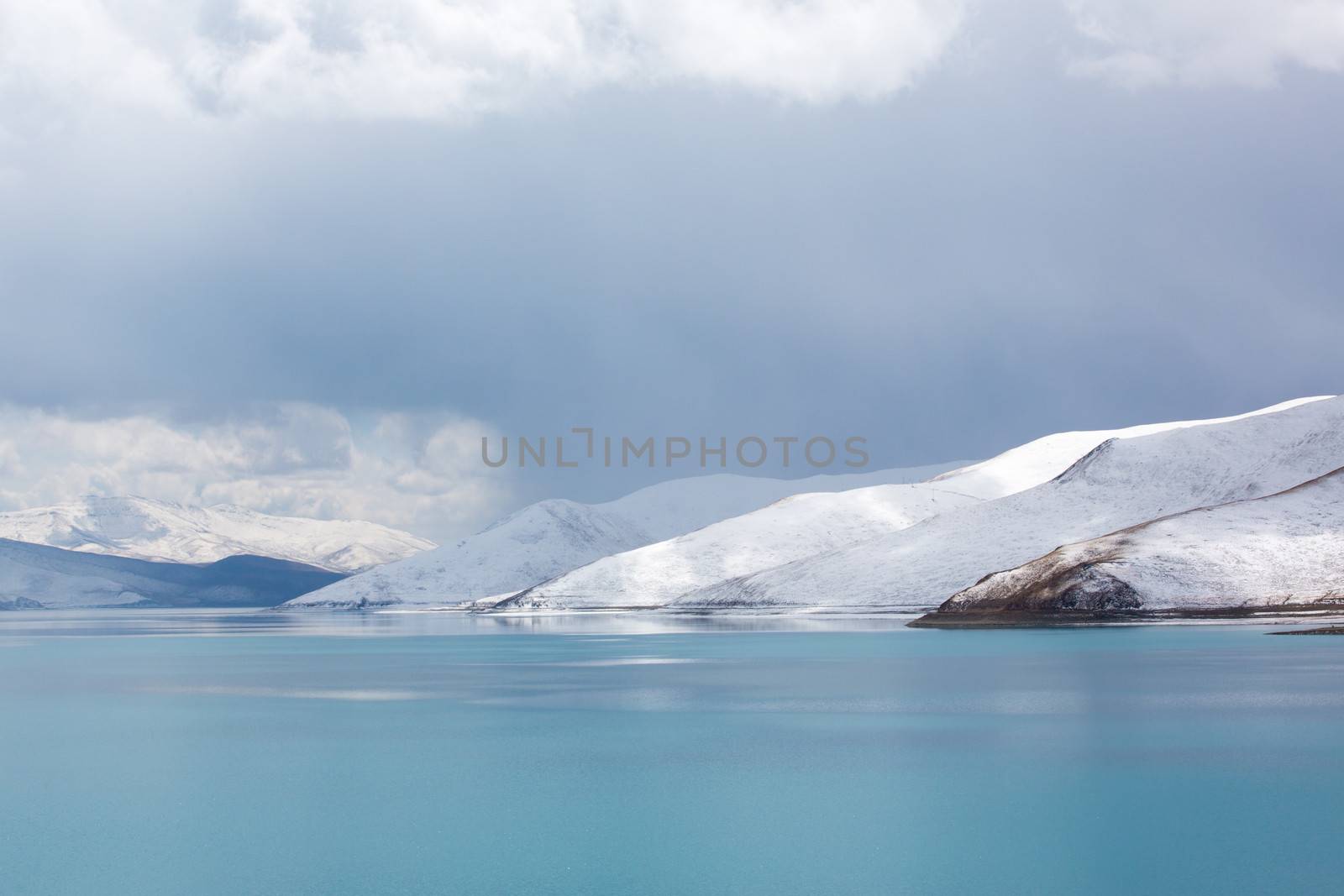Detail of the Yamdrok lake on the Friendship road in Tibet with snow on the mountains
