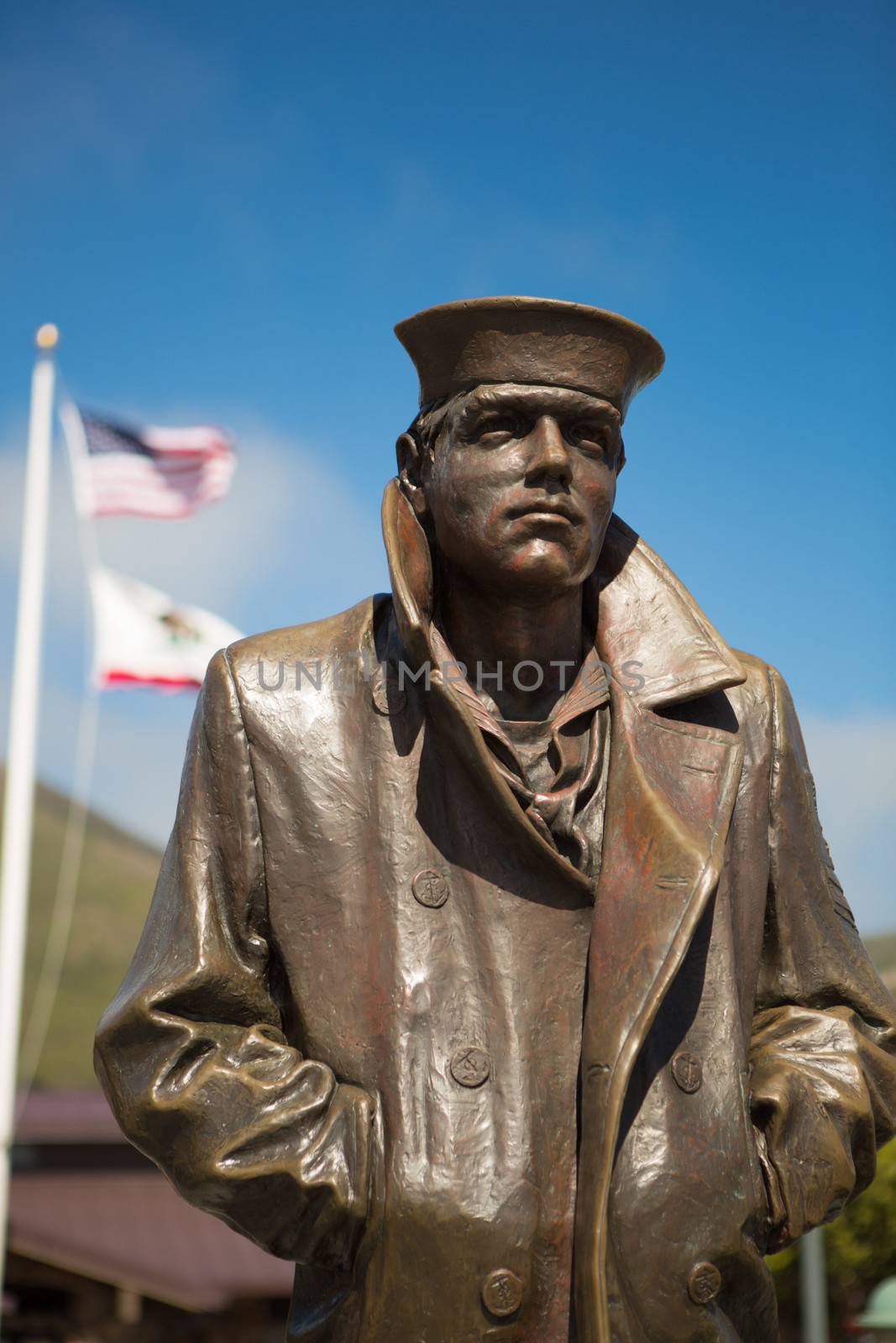 Statue the Sailor and the flags of the United States at the Golden Gate Bridge lookout area within the San Francisco Bay. United States 2012.
