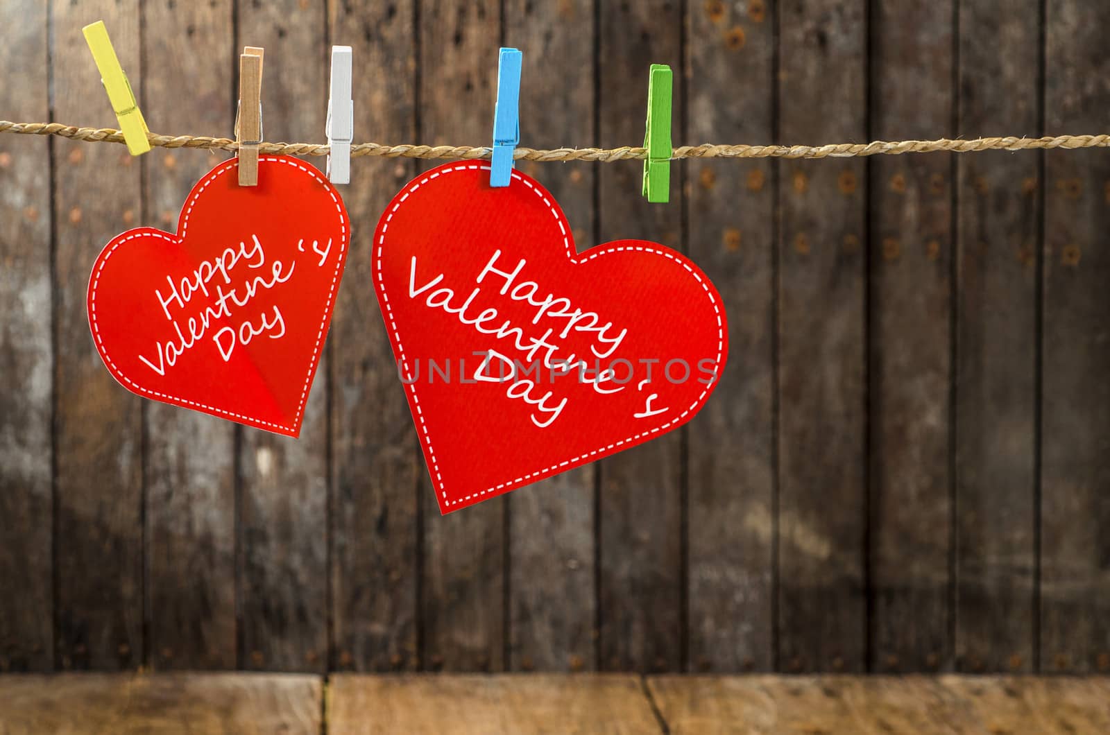 Red paper heart hanging on the clothesline. On old wood  by 9george