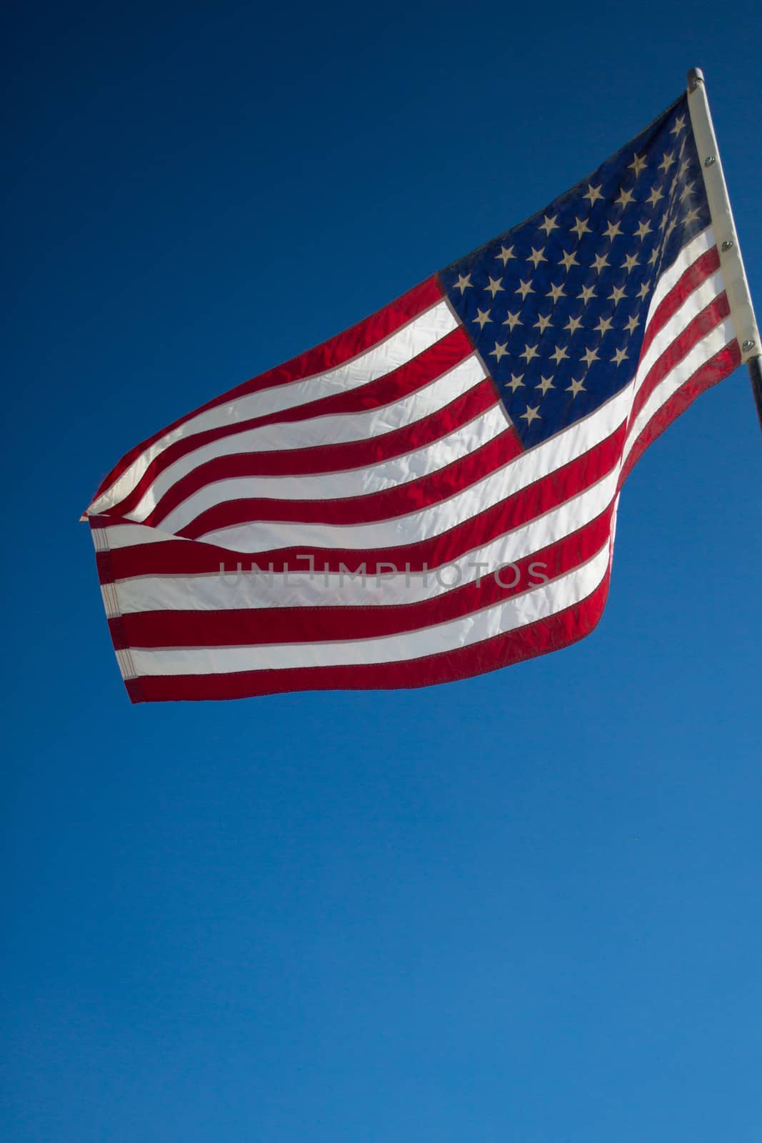 Waving American flag against cloudy sky