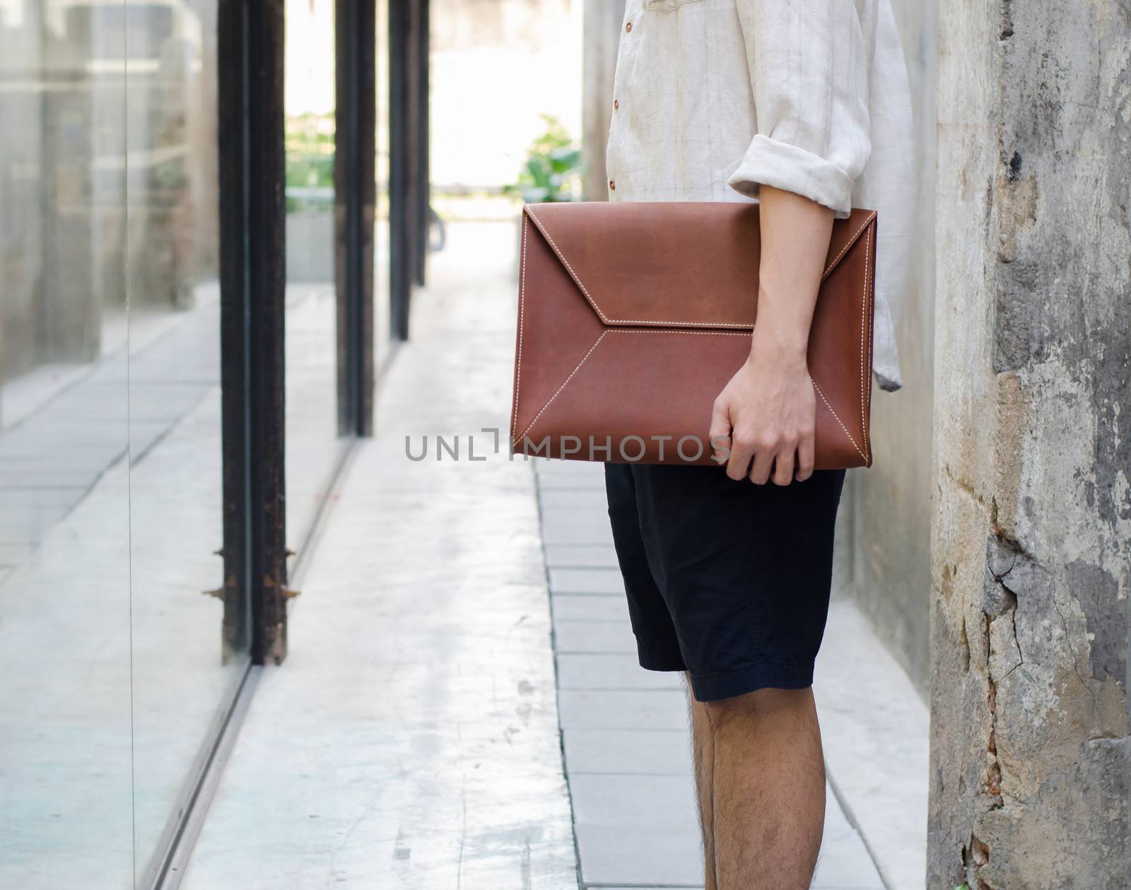 Man with leather bag on grunge concrete background