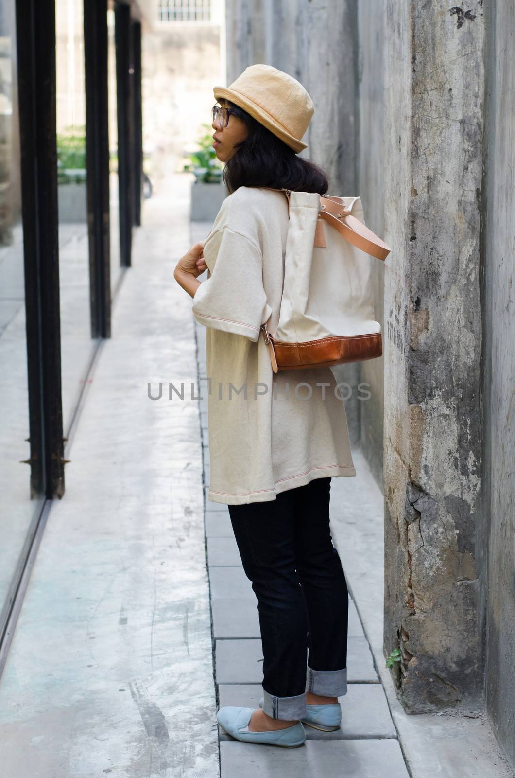 Young woman with a canvas bag, concrete background