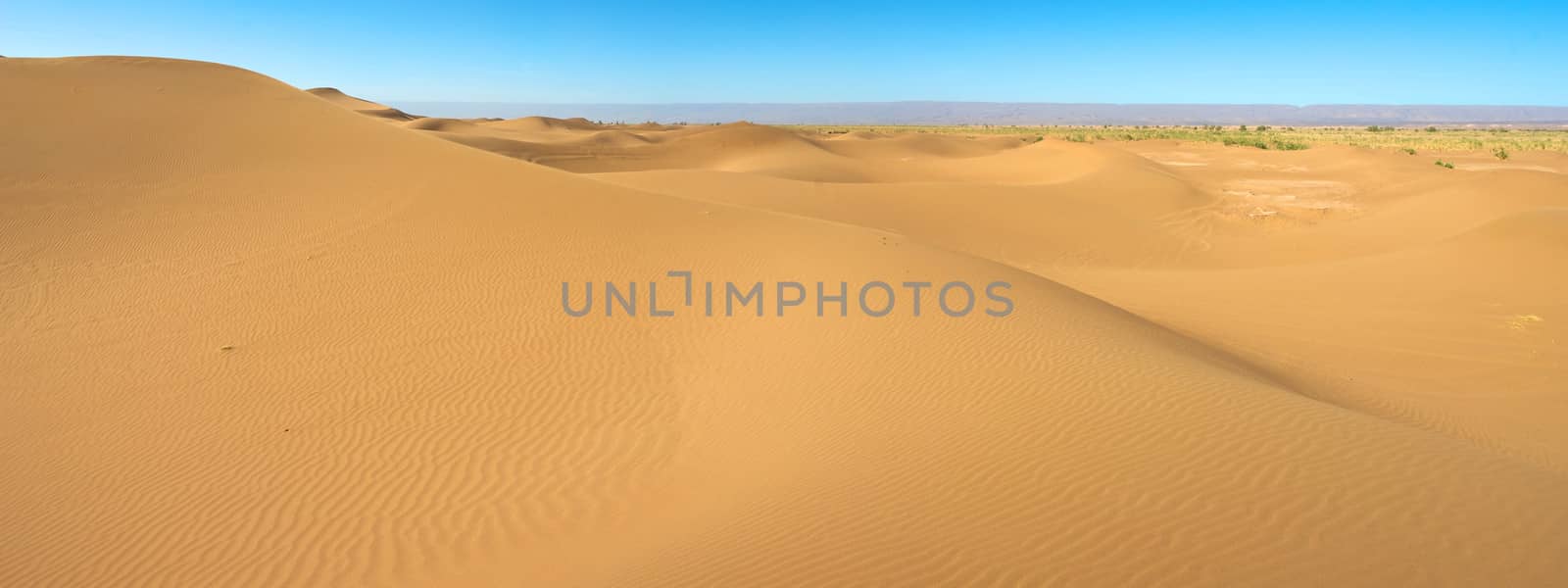 Sahara desert close to Merzouga in Morocco with blue sky and clouds.