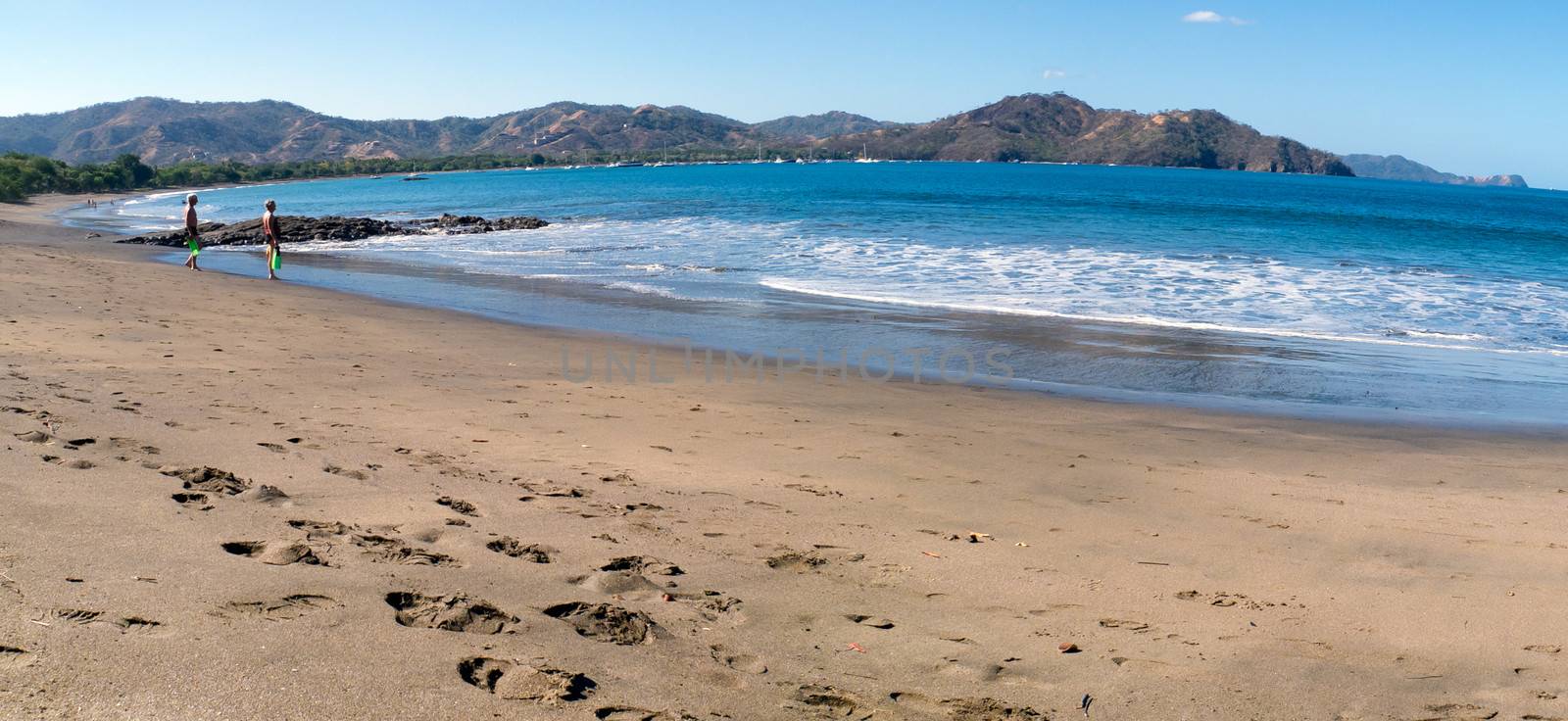 Panoramic photo with two unrecognizable people looking the Pacific Ocean in Bahia Coco, Costa RIca