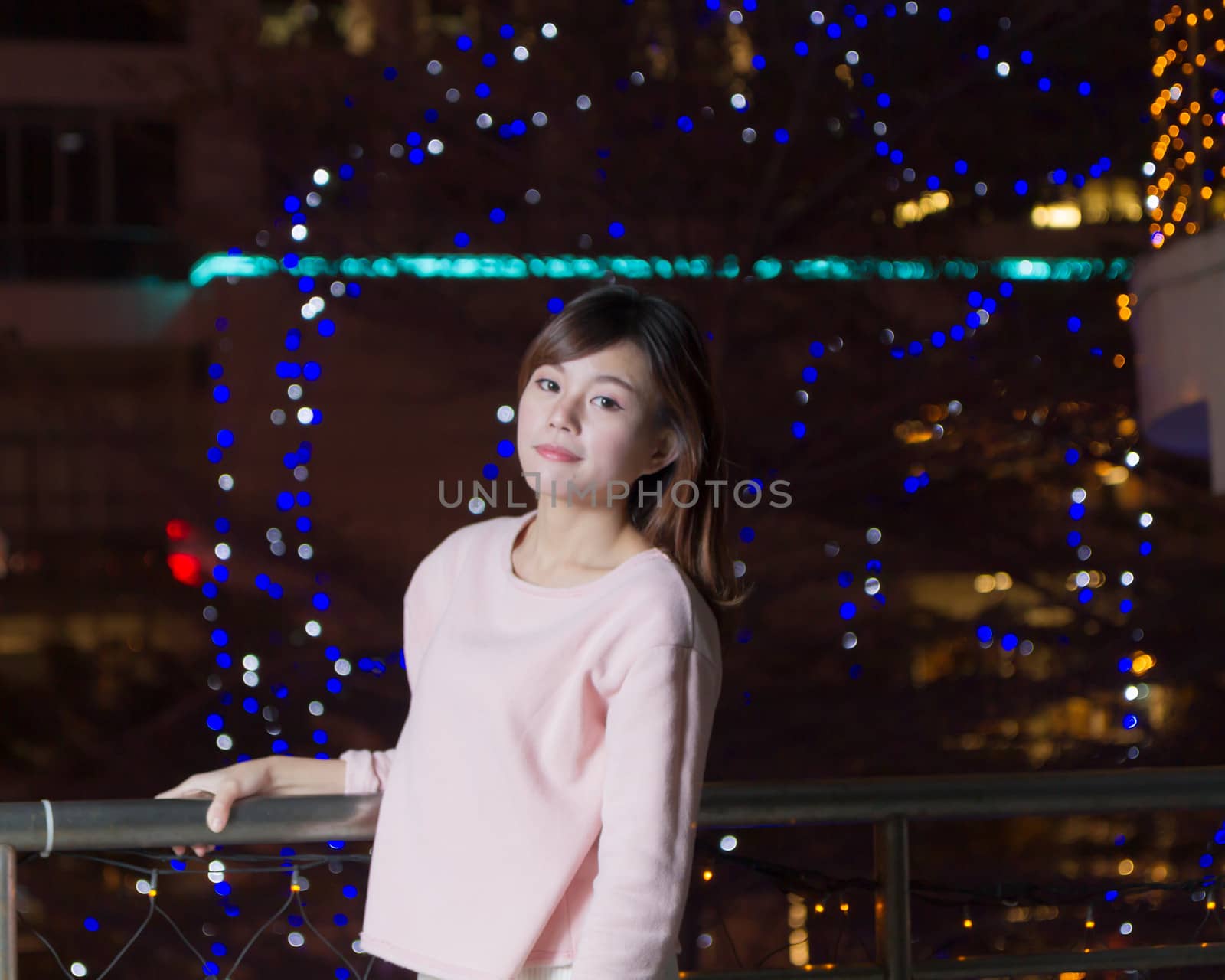 Pretty Malaysian female with blue lights behind her