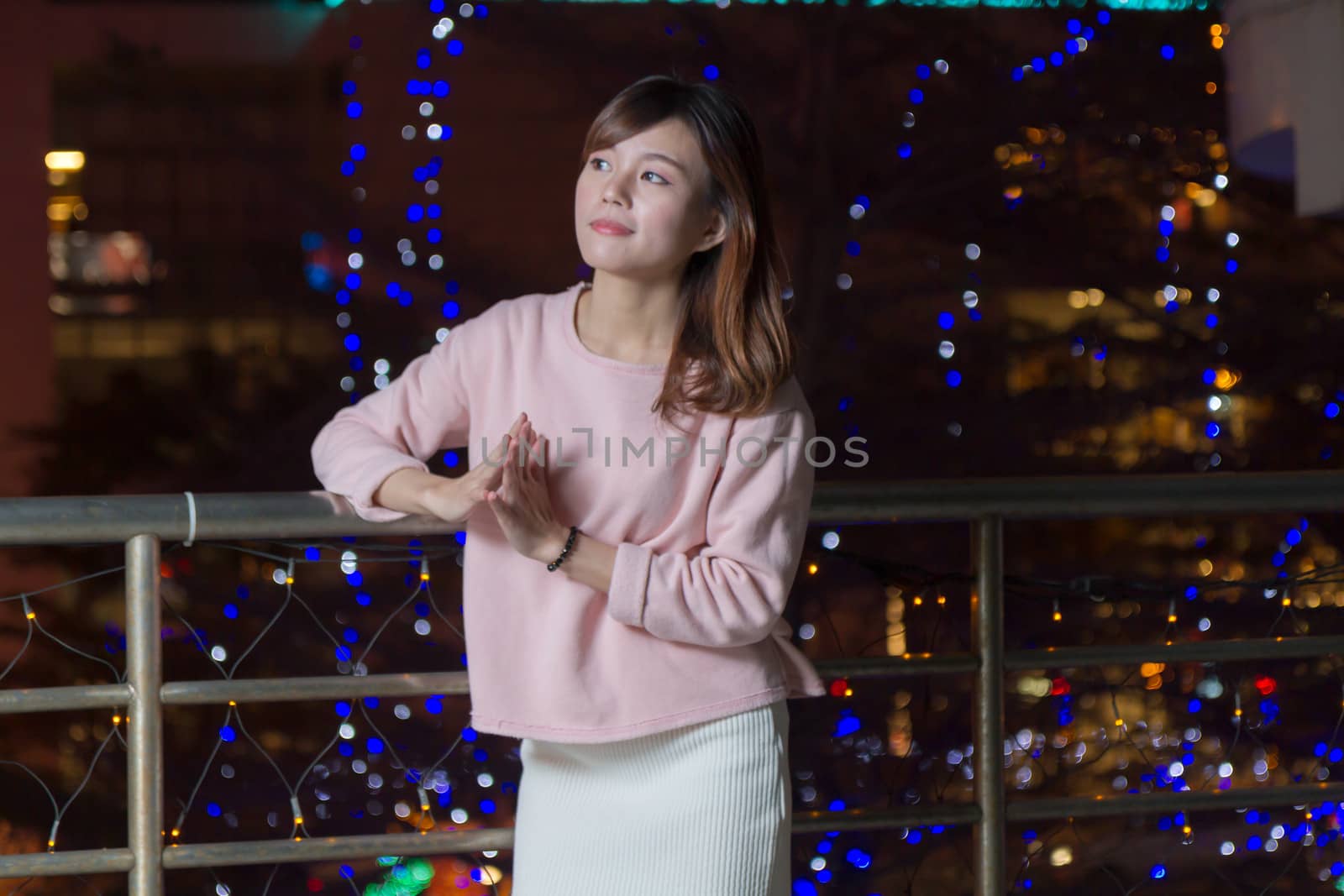 Pretty Malaysian female with blue lights behind her