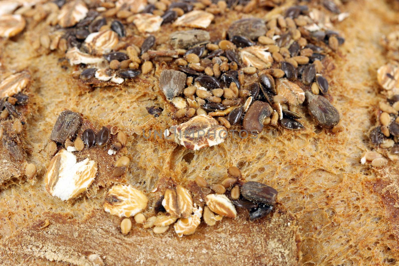 bread crust with seeds close up food background by goce