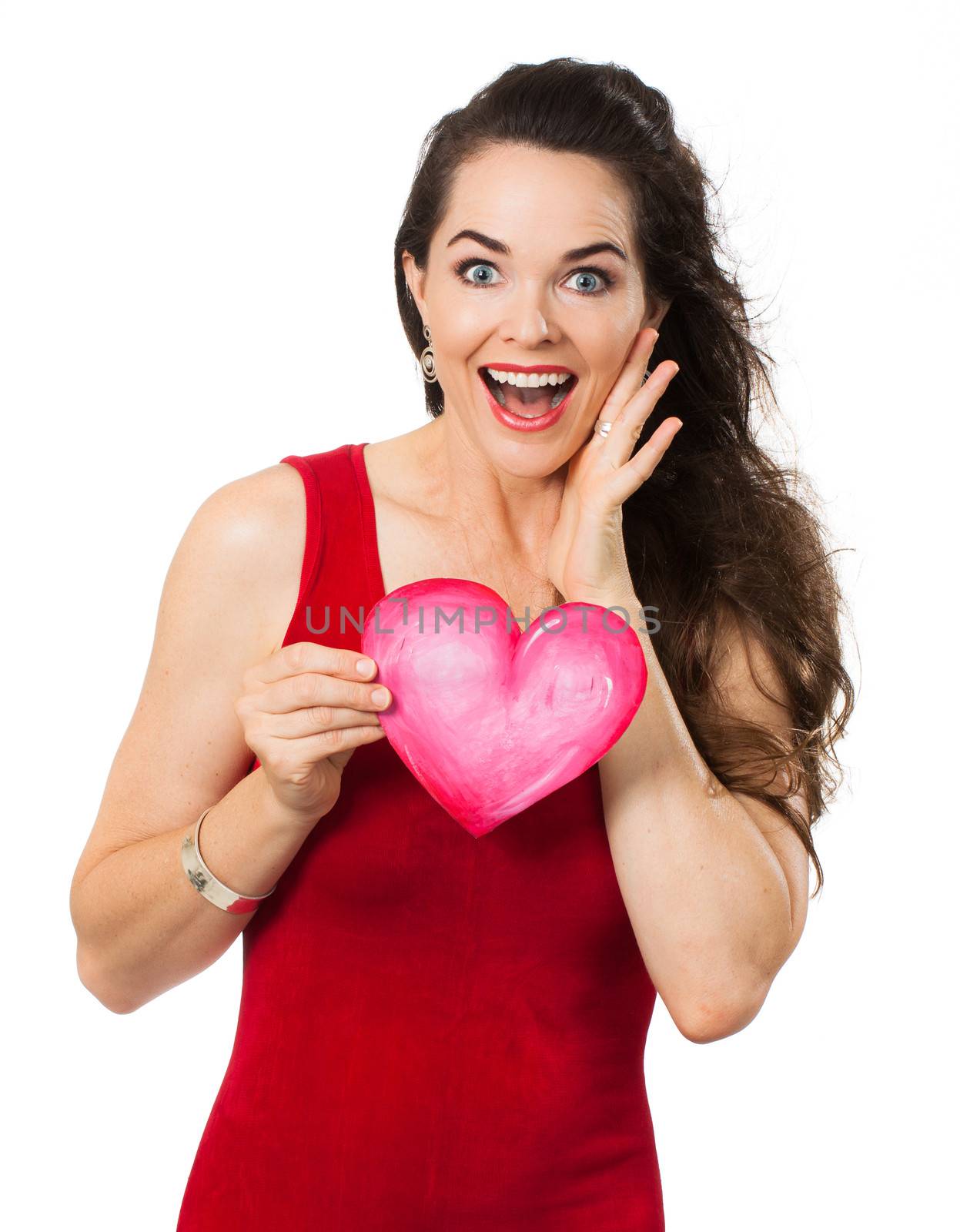 A beautiful happy surprised woman holding a red love heart. Isolated on white.